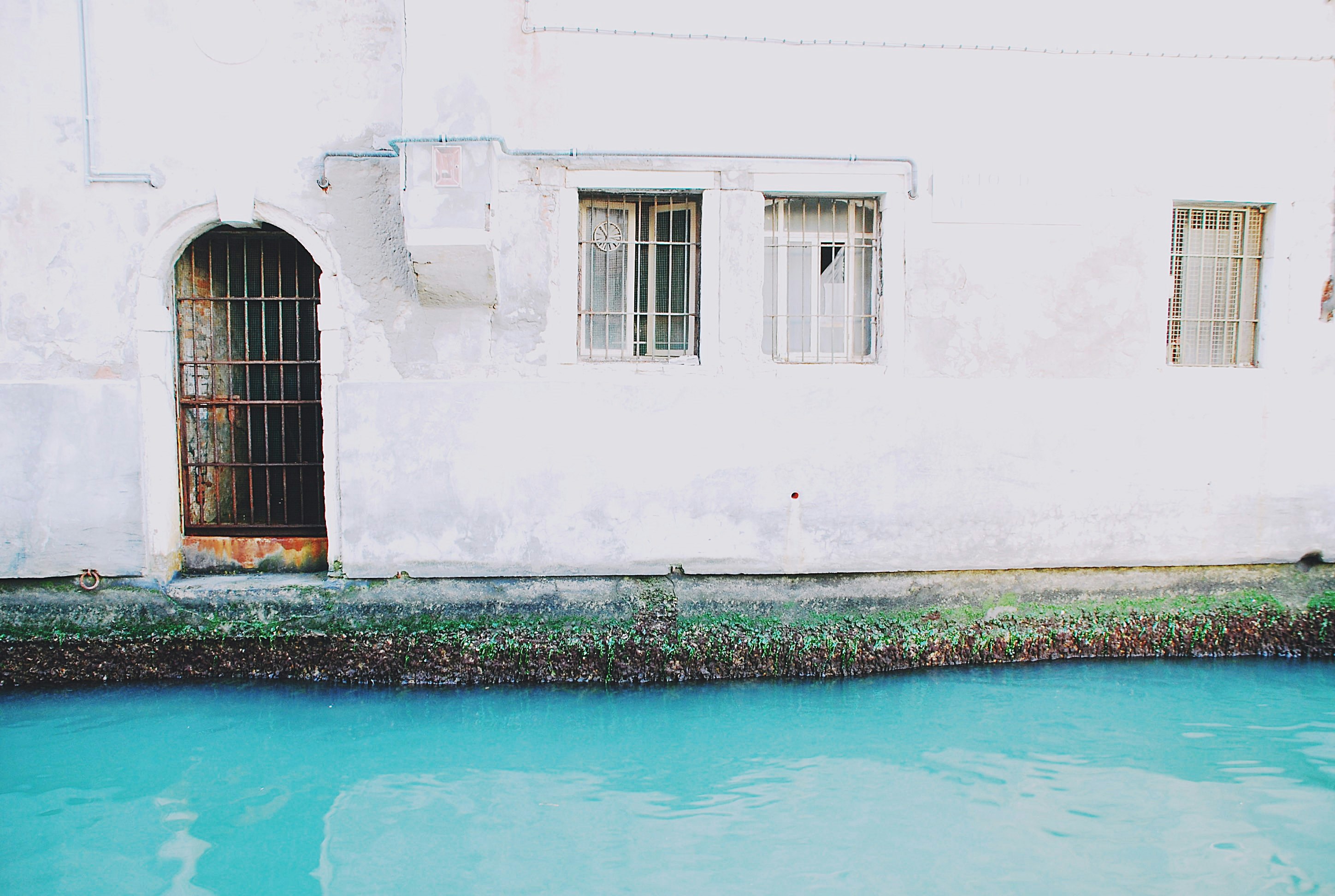 body of water beside white concrete house]